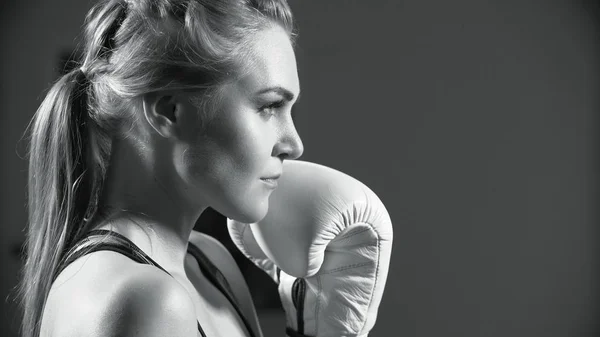 Female boxer. Young woman practices her boxing moves. Intense woman boxer throwing punches