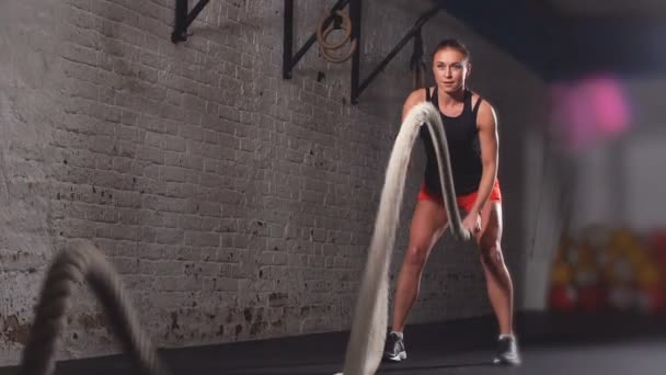 Athletic Female Actively In A Gym Exercises With Battle Ropes During Her Cross Fitness Workout Slow Motion