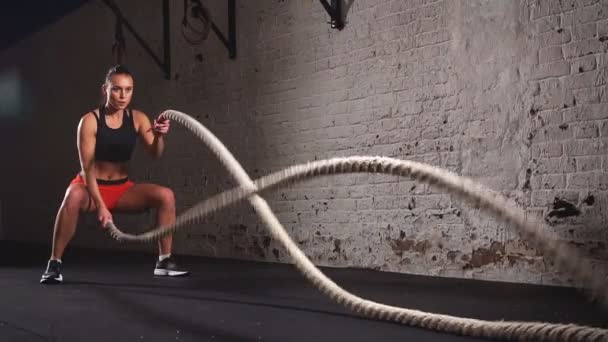 Young adult girl practising battle rope exercise during a cross fit workout at the gym. Slow motion — Stock Footage Young adult girl practising battle rope exercise during a cross fit workout at the gym. Slow motion Royalty Free Stock Video