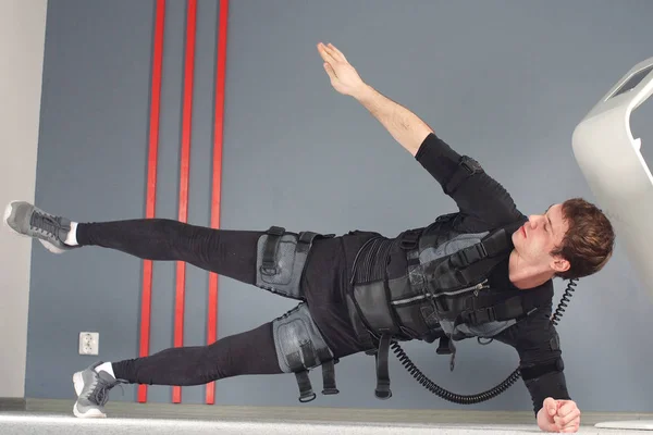 Fit Man in Electrical Muscular Stimulation Suits Doing Side Plank Exercise. EMS.