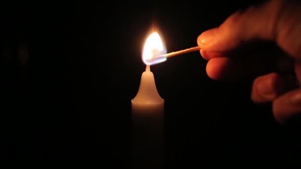 Primo piano di mens mano accende una candela da una partita — Video Stock