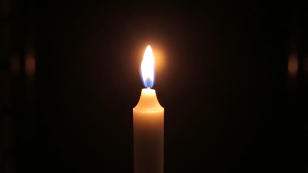 gros plan flamme de la bougie allumée sur fond noir 
