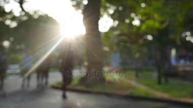 Ho Chi Minh city, Vietnam - Şubat, 2017: sun ray ile odak dışı. Kimliği belirsiz kişi çalıştıran ve sunshin ile bir parkta yürüyüş
