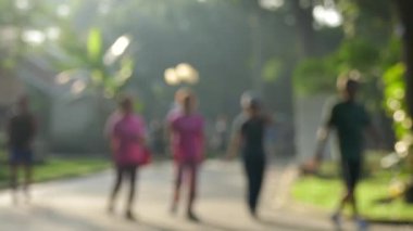 Ho Chi Minh city, Vietnam - Şubat, 2017: odak dışı. Kimliği belirsiz kişi çalıştıran ve güneş ışığı ile bir parkta yürüyüş. Ho Chi Minh city, Viet Nam