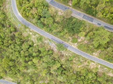 Üstten Görünüm. Bir dron havadan görünümden. Lisanslı yüksek kaliteli ücretsiz stok görüntü yolun ormanın içinde. Yolun ortasında bir orman ile birçok ağaç güzel, yol çok dolambaçlı geçmek ve eğri