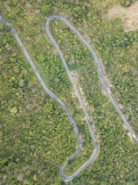 Üstten Görünüm. Bir dron havadan görünümden. Lisanslı yüksek kaliteli ücretsiz stok görüntü yolun ormanın içinde. Yolun ortasında bir orman ile birçok ağaç güzel, yol çok dolambaçlı geçmek ve eğri