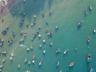 Hava manzaralı, denizde demirli balıkçı teknesi manzaralı. Tahta balıkçı tekneleri Mui Ne, Binh Thuan, Vietnam 'daki rıhtıma halatla demirlenmiş.