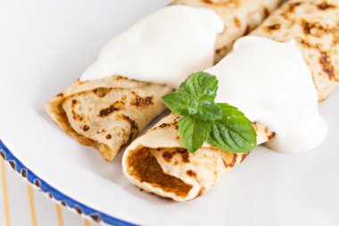 ince krepler ekşi krema nane ile pancakes tabağa haddelenmiş. 
