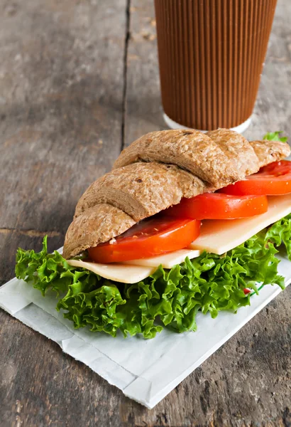 Grain vegetarian croissant sandwich and a paper cup of coffee on — Stock Photo, Image