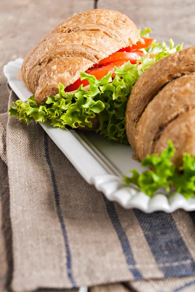 Grain vegetarian croissant sandwich on a plate on a wooden backg — Stock Photo, Image