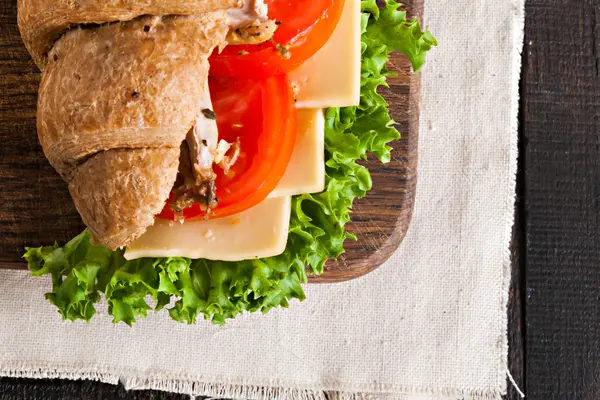 Grain croissant sandwich on a whiteboard and a dark background — Stock Photo, Image