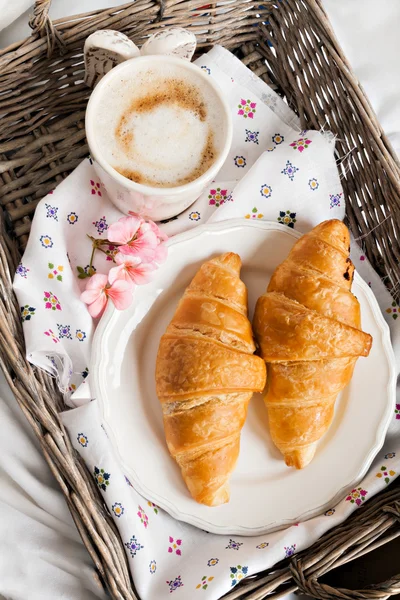 Croissants, coffee cup, flower in romantic style on a wicker tra — Stock Photo, Image