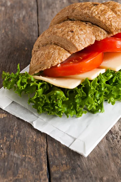 Grão vegetariano croissant sanduíche em um fundo de madeira velho — Fotografia de Stock