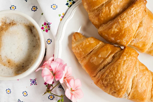 Croissants, xícara de café, flor em estilo romântico — Fotografia de Stock