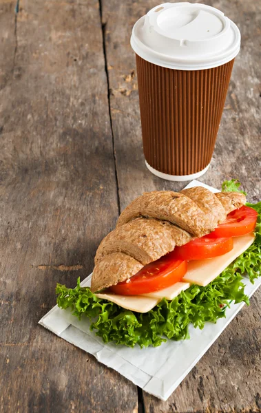 Sanduíche de croissant vegetariano grão e uma xícara de papel de café em — Fotografia de Stock