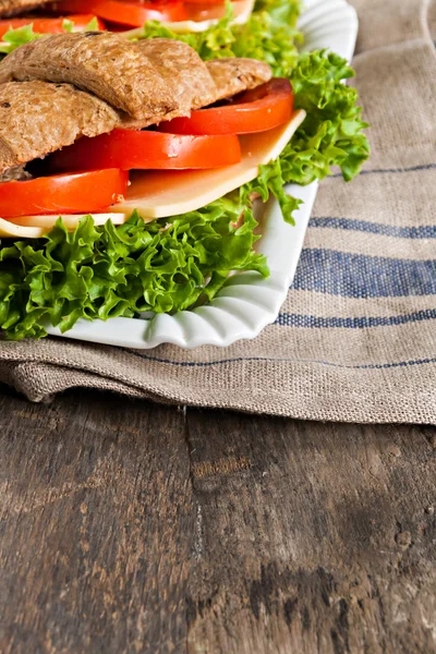 Grain vegetarian croissant sandwich on a plate on a wooden backg — Stock Photo, Image