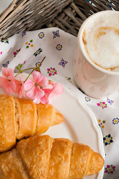 Croissants, coffee cup, flower in romantic style on a wicker tra — Stock Photo, Image