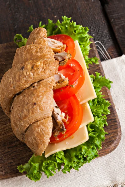 Grain croissant sandwich on a whiteboard and a dark background — Stock Photo, Image
