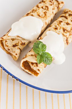 ince krepler ekşi krema nane ile pancakes tabağa haddelenmiş. 