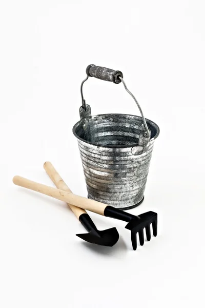 Pá de jardim, ancinho e um balde de metal isolado — Fotografia de Stock
