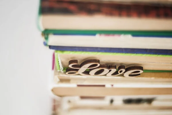 On a stack of old books wooden word love — Stock Photo, Image