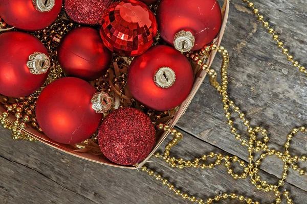Christmas balls red and gold, beads lie in a wooden basket top v — Stock Photo, Image