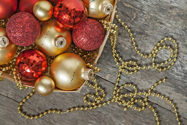 Christmas balls red and gold, beads lie in a wooden basket top v — Stock Photo, Image