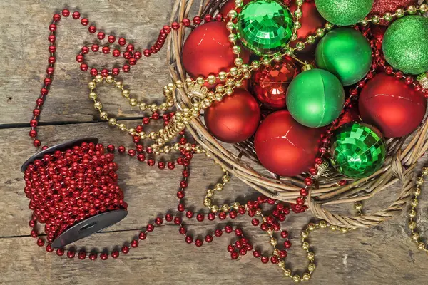 Bolas de Navidad rojo, oro, verde, cuentas se encuentran en una cesta de madera t —  Fotos de Stock