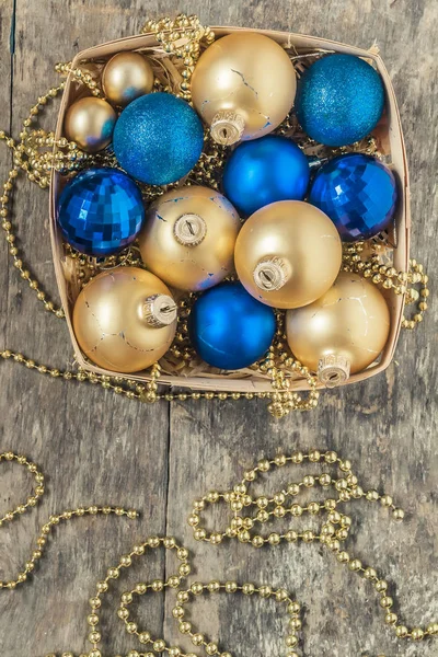 Bolas de Natal azuis e ouro, contas encontram-se em um top cesta de madeira — Fotografia de Stock