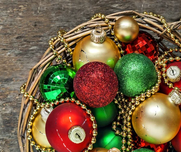 Christmas bollar röd, guld, grön, pärlor ligga i en trä korg t — Stockfoto