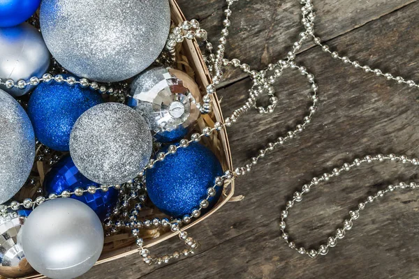 Blå julgranskulor och silver, pärlor ligga i en trä korg för att — Stockfoto