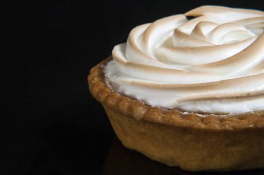 Limonlu kek beze tartı izole siyah bir arka plan ile 