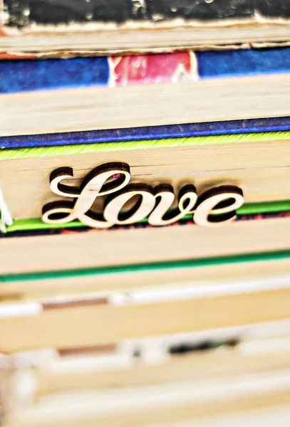 On a stack of old books wooden word love — Stock Photo, Image