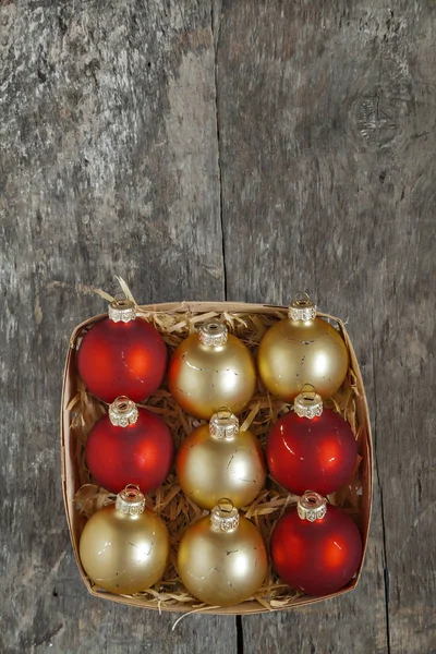 Vánoční koule červené a zlaté v dřevěný koš horní pohled vint — Stock fotografie