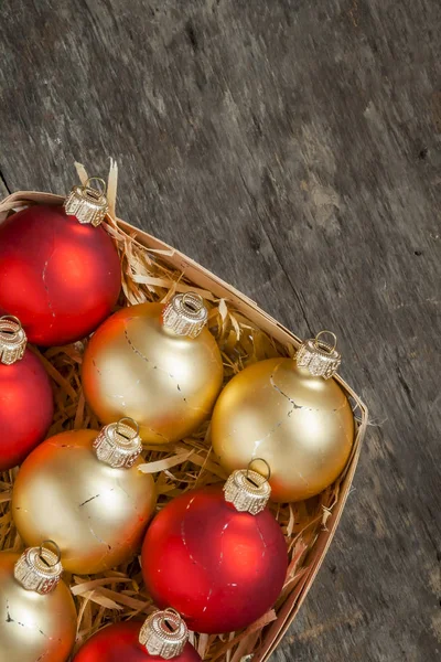 Kerst ballen rood en goud in een houten mand top bekijken van vint — Stockfoto