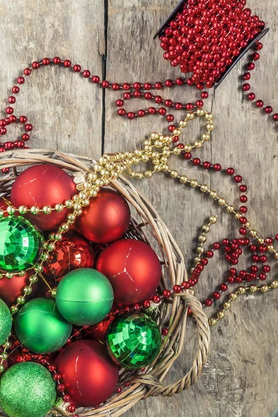 Rode kerstballen, goud, groen, kralen liggen in een houten mand t — Stockfoto