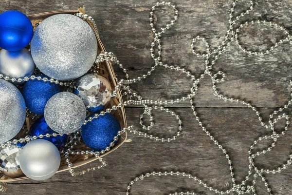 Blue Christmas balls and silver, beads lie in a wooden basket to — Stock Photo, Image