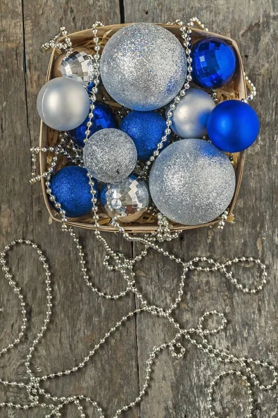 Μπλε Χριστούγεννα μπάλες και ασήμι, χάντρες βρίσκονται σε ένα ξύλινο καλάθι να — Φωτογραφία Αρχείου