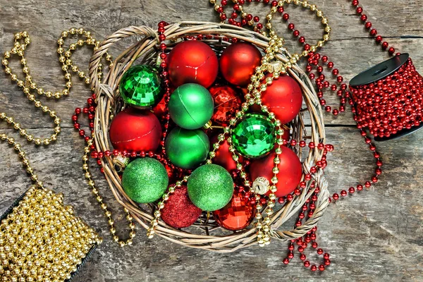 Rode kerstballen, goud, groen, kralen liggen in een houten mand t — Stockfoto