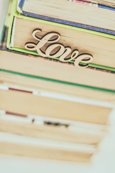 En una pila de libros antiguos palabra de madera amor — Foto de Stock