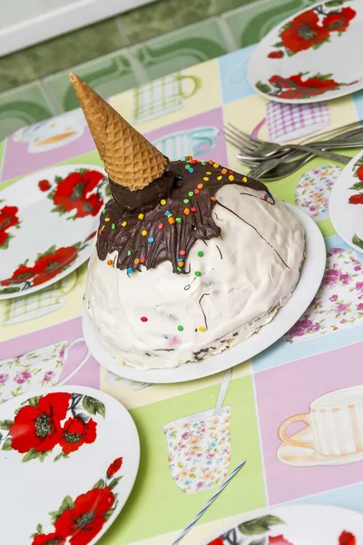 birthday cake in the form of a cone with ice cream on the table