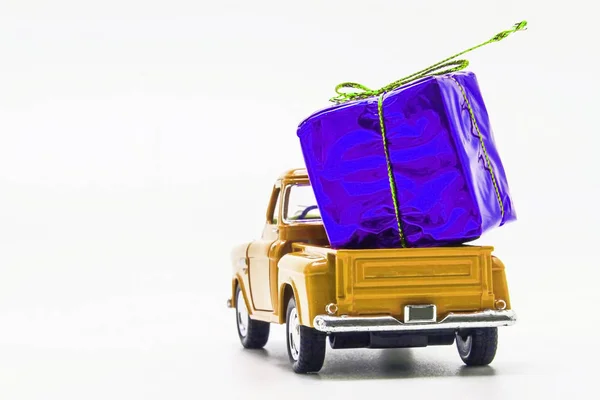 Sárga retro autó pickup lila ajándék doboz elszigetelt — Stock Fotó