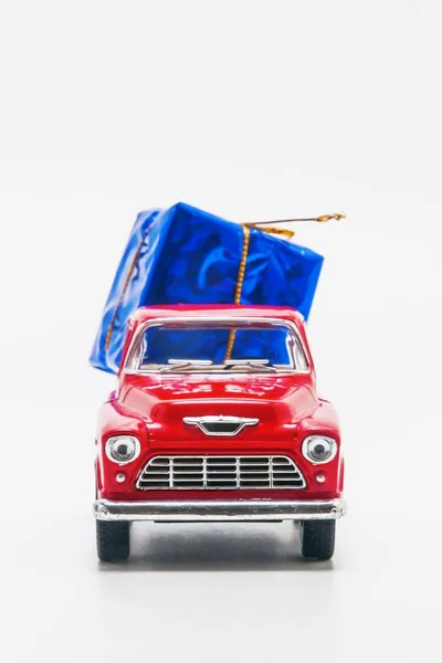 Rode retro auto ophalen met een blauwe geschenkdoos geïsoleerd — Stockfoto