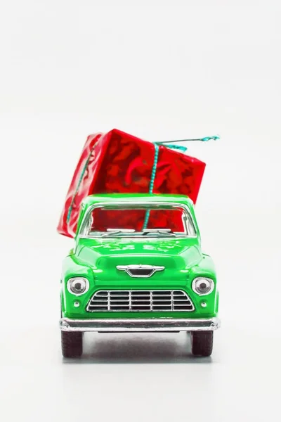 Groene retro auto ophalen met een rode giftdoos geïsoleerd — Stockfoto