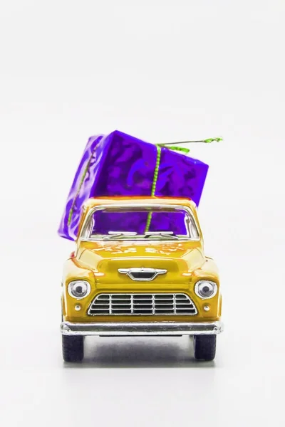 Gele retro auto pick-up violet geschenkdoos geïsoleerd — Stockfoto