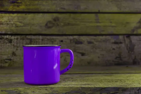 Violette Tasse auf altem hölzernem grünen Hintergrund — Stockfoto