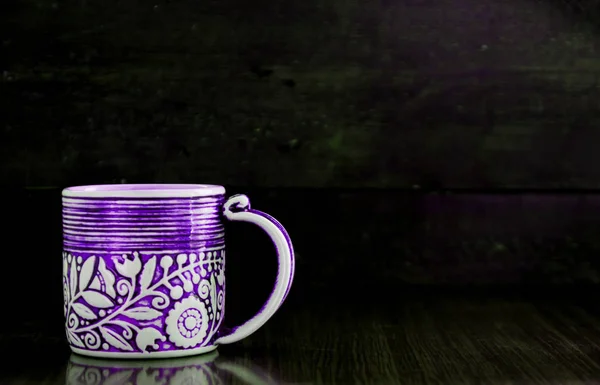 Tasse violette sur vieux fond sombre en bois — Photo