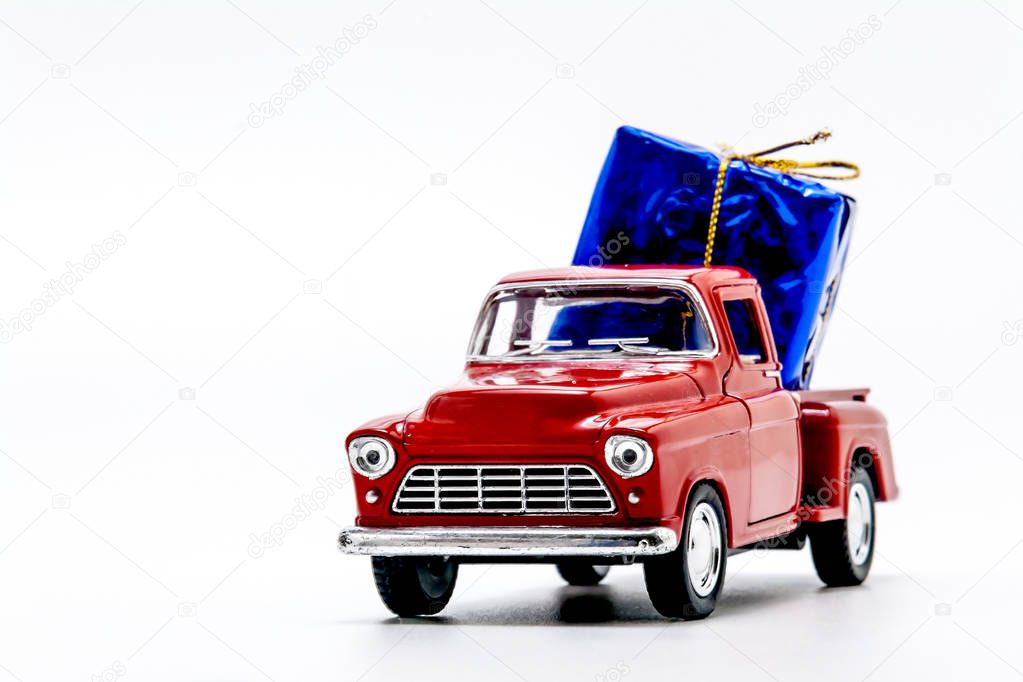 red retro car pickup with a blue gift box isolated