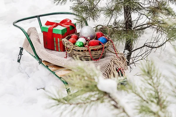 Έλκηθρα, κουβέρτα, καλάθι με τα παιχνίδια και δώρο κουτιά σε ένα χιονισμένο για — Φωτογραφία Αρχείου