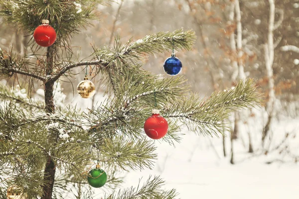Διακοσμημένο χριστουγεννιάτικο δέντρο σε ένα χιονισμένο πευκοδάσος με ρετρό αποτε — Φωτογραφία Αρχείου